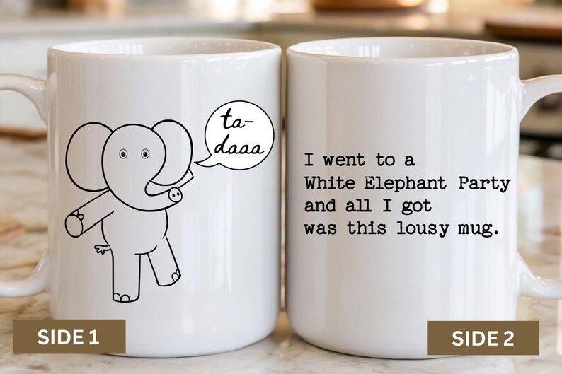 May include: A white ceramic mug featuring a black line drawing of an elephant with a speech bubble saying ta-daaa on one side and the black text I went to a White Elephant Party and all I got was this lousy mug on the other side.