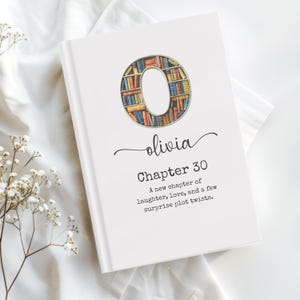Puede incluir: Un libro de tapa dura blanco con el nombre "olivia" en cursiva y "Capítulo 30" impreso debajo. La letra "O" es un recorte relleno con una ilustración de estantería. El texto dice: "Un nuevo capítulo de risas, amor y algunos giros inesperados."