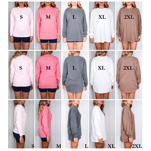 May include: A size guide for Comfort Colors 6014 long-sleeve shirts. The guide shows the fit of the shirts in sizes S, M, L, XL, and 2XL. The model is 5'8" tall, weighs 145 lbs, with a 37" chest, 32" waist, and 42" hips. The fits are fitted, regular, relaxed, loose, and oversized.