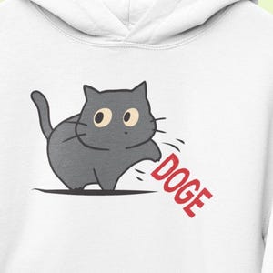 Cat Knocking DOGE Off Table Funny Hoodies Anti Trump Anti Elon Musk DOGE Humorous Cute Cats Sweatshirts Gifts Hilarious