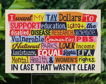May include: A rectangular sign with a cream background and colorful text. The text reads "I want MY TAX Dollars TO SUPPORT education, LGBTQ+, the disabled, DISEASE RESEARCH, science, Vulnerable Communities, PBS, National PARKS, LOWER Income Assistance, EQUAL Rights, EPA, Mental Health, & WOMEN'S rights. IN CASE THAT WASN'T CLEAR."