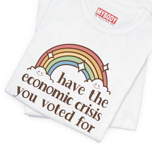 May include: White t-shirt with a rainbow and clouds graphic and the text "have the economic crisis you voted for".