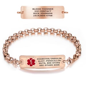 Pode incluir: Pulseira de identificação médica em ouro rosa com design de elos de corrente. A placa retangular apresenta o texto "DIABETES/INSULINA, ALGY: PENICILINA, NOZES, PICADA DE ABELHA, VEJA O OUTRO LADO" e um símbolo médico vermelho. Uma placa separada diz "ANTICOAGULANTE, CONTACTO ICE, RICK JOHNSON, (619)866-4768".
