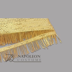 May include: Gold fringe trim with a woven texture. The fringe is approximately 2.5 cm wide.