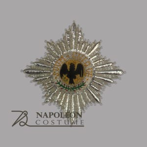 以下が含まれることがあります： 黒い鷲と円の中に「PROU ET GUI DE」という文字が書かれた銀色の星形バッジ。鷲はくちばしで王冠をくわえている。