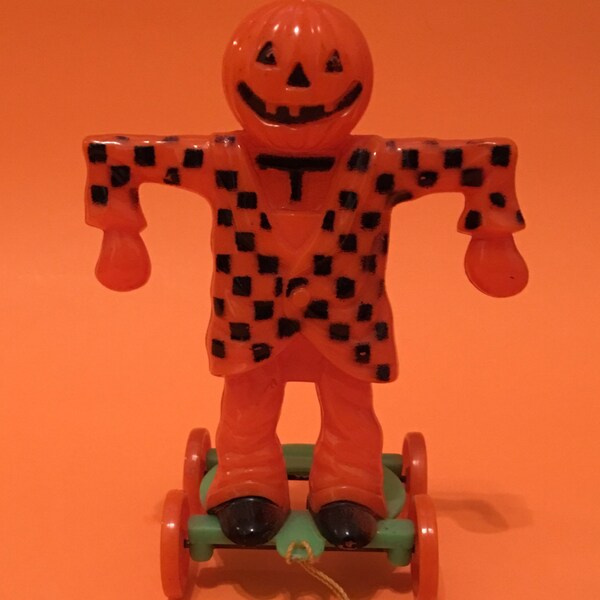 Vintage Plastic Pumpkin Scarecrow on Wheels candy container