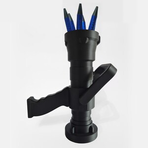 May include: A black pen holder shaped like a fire hose nozzle, with a handle and base. The pen holder contains several blue pens. The design is 3D printed and sits on a white surface.