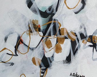 Könnte beinhalten: Abstrakte Malerei mit schwarzer, weißer und goldener Farbe auf einer weißen Leinwand. Das Gemälde zeigt geometrische Formen und Linien.