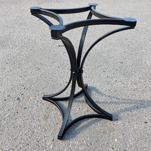 Può includere: Base per tavolo in metallo nero dal design decorativo. La base presenta una parte superiore a quattro punti per un piano del tavolo e gambe curve che si incontrano al centro. Adatta per uso interno o esterno. Altezza: circa 76 cm.