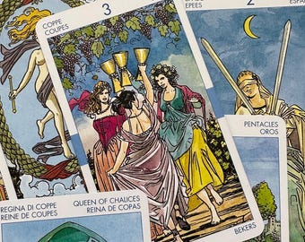 May include: A tarot card spread with various cards from the Rider-Waite tarot deck. The cards include The World, Queen of Cups, 3 of Cups, 2 of Swords, and 8 of Pentacles. The cards are laid out on a blue background.