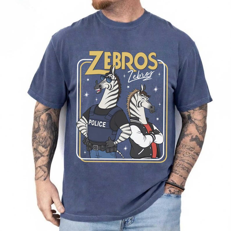 May include: Navy blue t-shirt with a graphic of two zebras. One is dressed as a police officer, the other in a jacket. The text "ZEBROS" is above the zebras, with "Zebros" in script below.