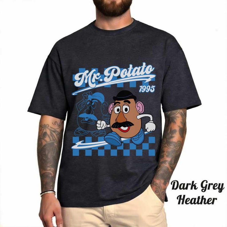 May include: Dark grey heather t-shirt featuring a Mr. Potato Head graphic. The design includes the text "Mr. Potato 1995" in a blue and white checkered background. The shirt has short sleeves.