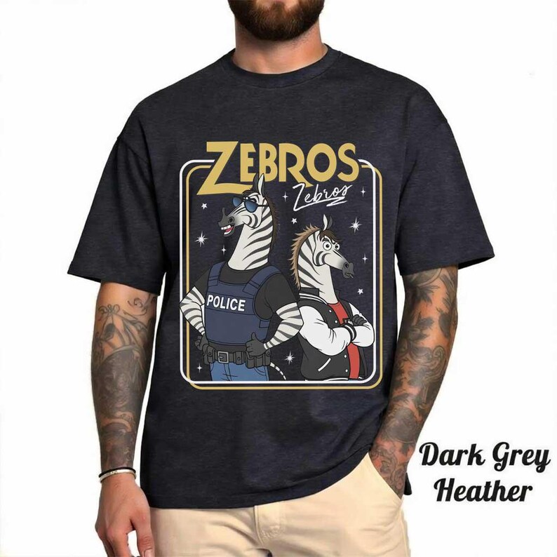 May include: Dark grey heather t-shirt with a cartoon illustration of two zebras. One zebra is in a police vest, the other in a letterman jacket. The text "ZEBROS" is above the zebras, with "Zebros" below.
