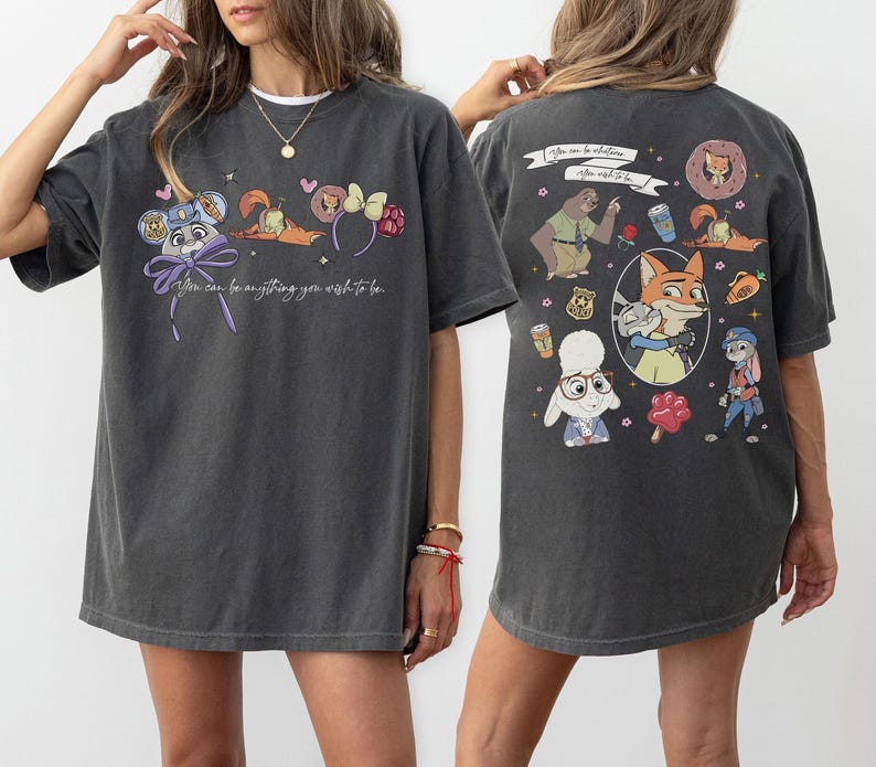 Puede incluir: Camiseta gris oscuro con personajes de dibujos animados y el texto "You can be anything you wish to be." La parte trasera de la camiseta tiene m&aacute;s personajes de dibujos animados y el texto "After all, to be."