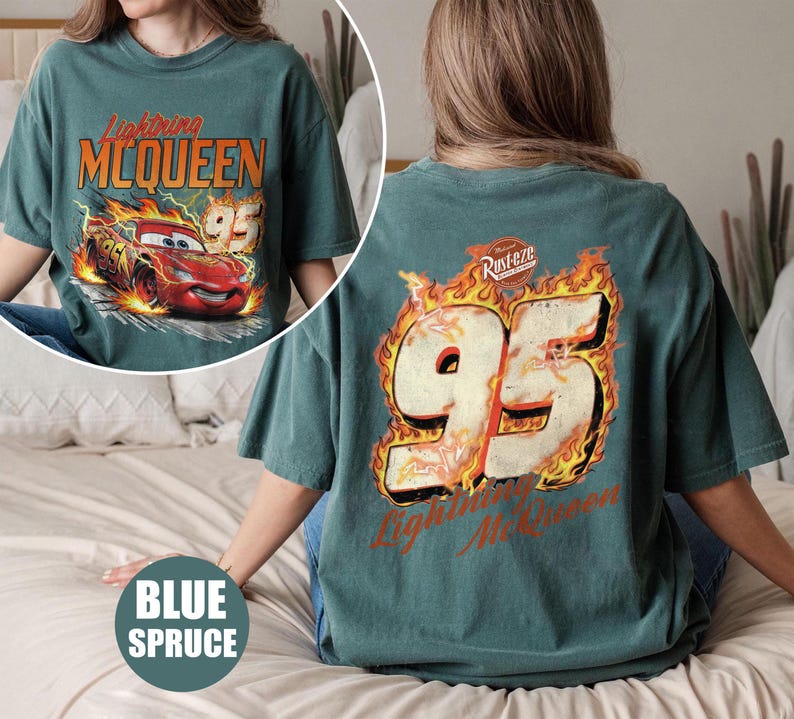 May include: Blue spruce t-shirt featuring Lightning McQueen from the movie Cars. The front graphic shows McQueen racing with the number 95. The back of the shirt displays the number 95 in flames with the text "Lightning McQueen".