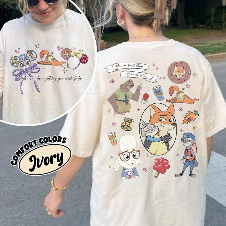 Puede incluir: Camiseta de manga larga color marfil con personajes de dibujos animados y el texto "You can be anything you wish to be." La camiseta tiene cuello redondo y un dise&ntilde;o gr&aacute;fico en la parte delantera y trasera. La camiseta est&aacute; etiquetada como "Comfort Colors."