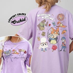 Puede incluir: Camiseta Orchid Comfort Colors de color lila claro con personajes de dibujos animados. La camiseta tiene un dise&ntilde;o en la parte delantera y trasera con el texto "You can be anything you wish to be." La camiseta es de color lila claro.