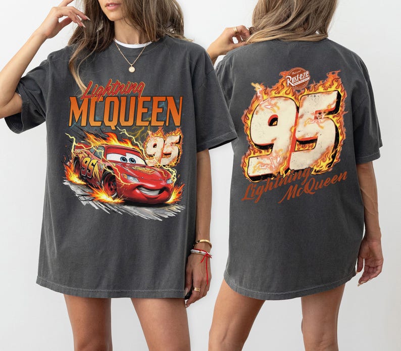 May include: Dark gray Lightning McQueen t-shirt. The front features a graphic of the red race car with the number 95 and the text "Lightning McQueen". The back of the shirt has the number 95 in flames and the text "Lightning McQueen".