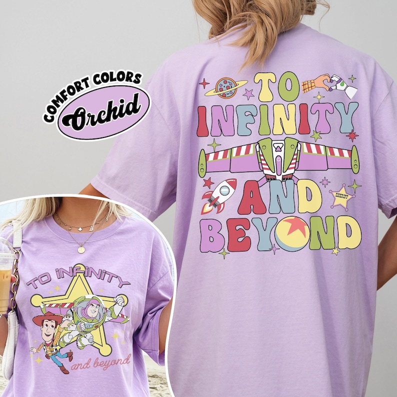 May include: A light purple t-shirt with the phrase "TO INFINITY AND BEYOND" in colorful letters and graphics. The shirt also features a graphic of Buzz Lightyear and Woody. The shirt has the words "Comfort Colors" and "Orchid" printed on it.