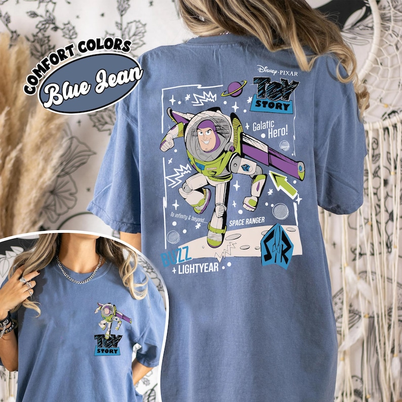 K&ouml;nnte beinhalten: Blaues Jeans-T-Shirt mit einer Grafik von Buzz Lightyear aus Toy Story. Das Design enth&auml;lt den Text "Toy Story", "Galactic Hero!" und "Space Ranger". Das Shirt hat auch den Text "Comfort Colors" und "Blue Jean".