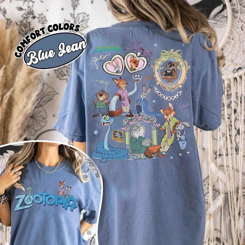 Puede incluir: Camiseta azul vaquero con la palabra "Zootopia" en letras turquesas. La parte trasera de la camiseta presenta un gr&aacute;fico colorido de personajes de la pel&iacute;cula animada "Zootopia". La camiseta tambi&eacute;n tiene las palabras "Comfort Colors" y "Blue Jean".