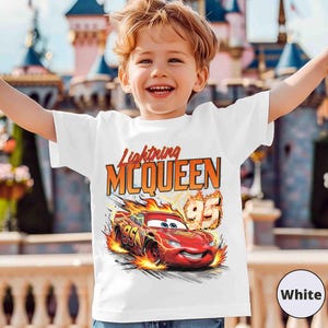 Puede incluir: Camiseta blanca con Lightning McQueen de la pel&iacute;cula Cars. El dise&ntilde;o incluye el texto "Lightning McQueen" en naranja y rojo, junto con un gr&aacute;fico del coche de carreras rojo y el n&uacute;mero 95.