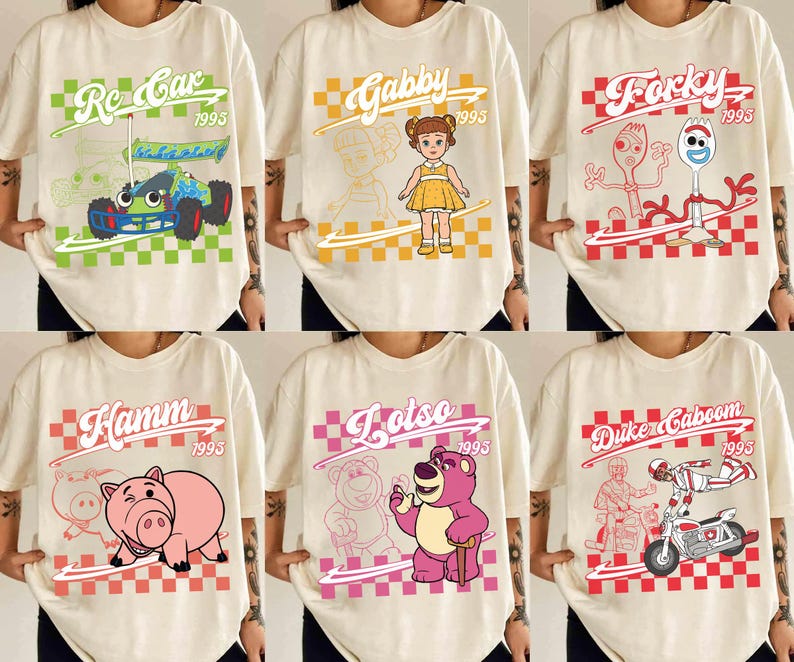 May include: Cream-colored t-shirts featuring various cartoon characters and text. Designs include a race car, a doll, a fork and spoon, a pig, a bear, and a motorcycle rider. Each design is set against a checkered background.