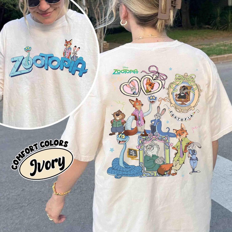 Puede incluir: Camiseta de color marfil con la palabra "Zootopia" en azul y personajes de dibujos animados. La parte trasera de la camiseta muestra un gr&aacute;fico m&aacute;s grande con varios personajes de Zootopia y el logotipo de Disney. La camiseta es de color confort.