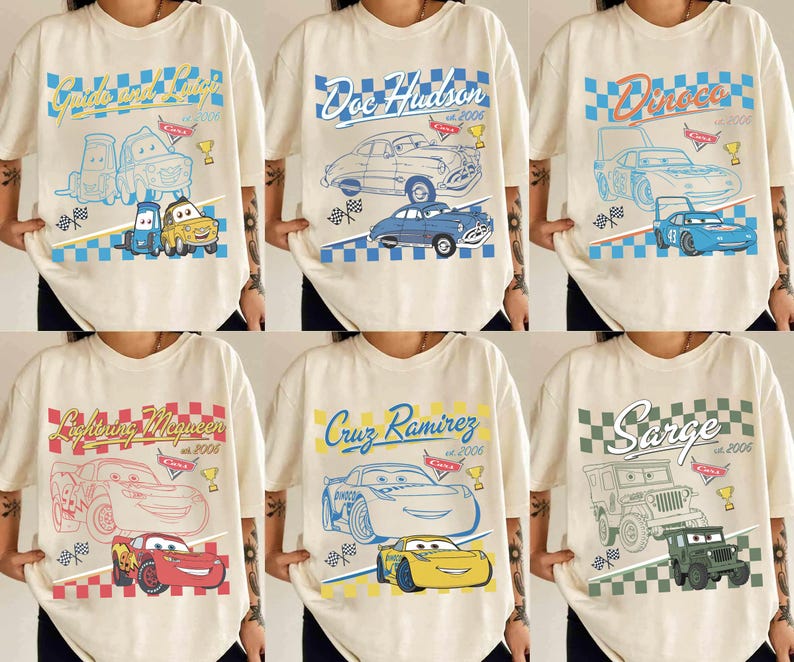 May include: Cream-coloured t-shirts featuring characters and designs from the animated film "Cars." Each shirt displays a character's name, a car illustration, and the year "2006" or "2005" in a retro style. The designs include blue, red, yellow, and green accents.