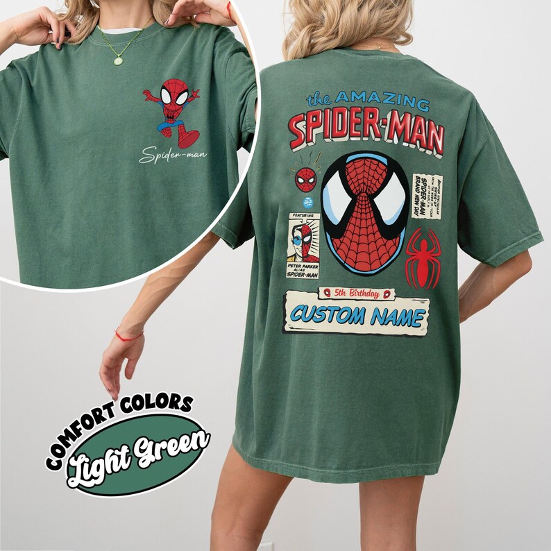 May include: Light green t-shirt featuring a Spider-Man graphic on the front and back. The front has a small Spider-Man cartoon and the text "Spider-man". The back has a large Spider-Man graphic with the text "The Amazing Spider-Man" and "Custom Name".