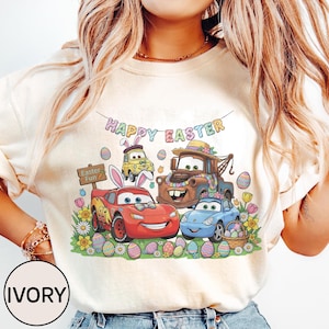 Può includere: Felpa color avorio con una grafica colorata dei personaggi di Cars che celebrano la Pasqua. Il design include il testo "Happy Easter" e "Easter Fun", insieme a uova di Pasqua e fiori. I personaggi di Cars sono decorati con orecchie da coniglio pasquale.