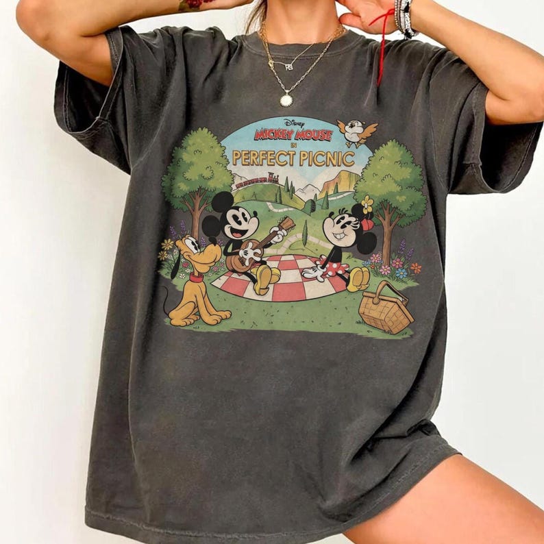 May include: Dark gray t-shirt featuring a vintage-style graphic of Mickey Mouse, Minnie Mouse, and Pluto having a picnic. The graphic includes the text "Disney Mickey Mouse PERFECT PICNIC" in a circular design with a landscape background.