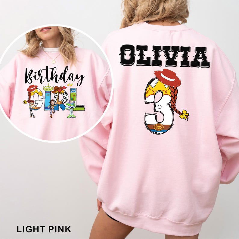May include: Light pink sweatshirt with the text "Birthday Girl" and Toy Story character graphics on the front. The back features the name "Olivia" and a number 3 with a cowgirl design. The bottom of the image says "LIGHT PINK".