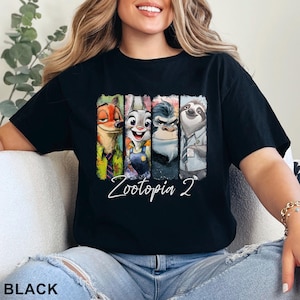 Peut inclure: T-shirt noir avec un graphisme color&eacute; des personnages de Zootopie 2. Le design comprend Nick Wilde, Judy Hopps, le chef Bogo et Flash. Les mots "Zootopia 2" sont &eacute;crits en cursive en dessous des personnages. Le mot "BLACK" est en bas.