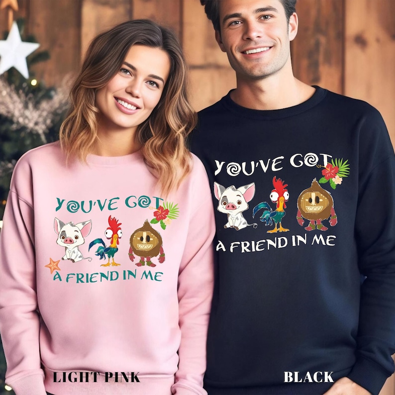 May include: Two matching sweatshirts with a pink and a black color. The sweatshirts feature a graphic of characters from the Disney movie Moana. The text on the sweatshirts reads "You've got a friend in me".
