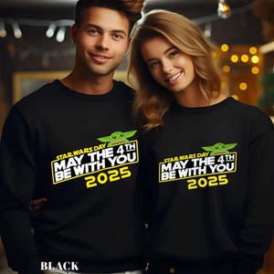May include: Black sweatshirts featuring the text "STAR WARS DAY MAY THE 4TH BE WITH YOU 2025" in yellow and white, with a green cartoon character. The word "BLACK" is at the bottom of the image.