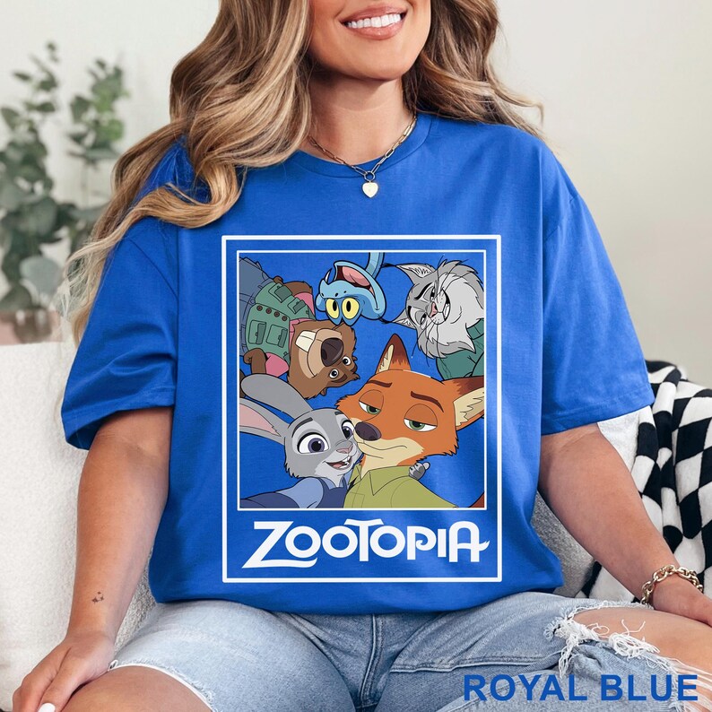 Peut inclure: T-shirt bleu roi avec un motif du film d'animation Zootopie. Le design pr&eacute;sente des personnages comme Judy Hopps et Nick Wilde, avec le titre du film en blanc. Le t-shirt est bleu vif.