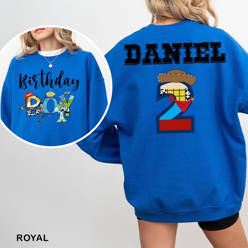 May include: Royal blue sweatshirt with the text "Birthday Boy" and a graphic of a cartoon character on the front. The back of the sweatshirt has the name "DANIEL" and a number 2 with a cowboy hat and bandana design.