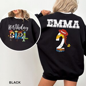 May include: Black sweatshirt with white trim featuring the text "Birthday Girl" and cartoon characters. The back of the sweatshirt has the name "EMMA" and a "2" with a cowgirl hat and braid design.