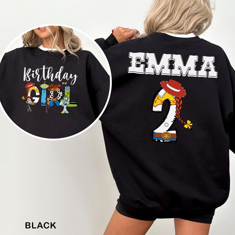May include: Black sweatshirt with white trim featuring the text "Birthday Girl" and cartoon characters. The back of the sweatshirt has the name "EMMA" and a "2" with a cowgirl hat and braid design.