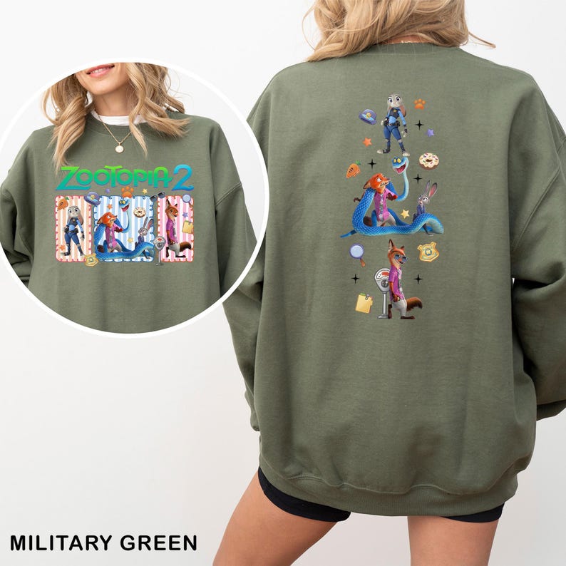 May include: Military green sweatshirt featuring characters from Zootopia 2. The front displays the title and characters, while the back showcases a larger design with Judy Hopps, Nick Wilde, and other characters. A fun, colorful design.