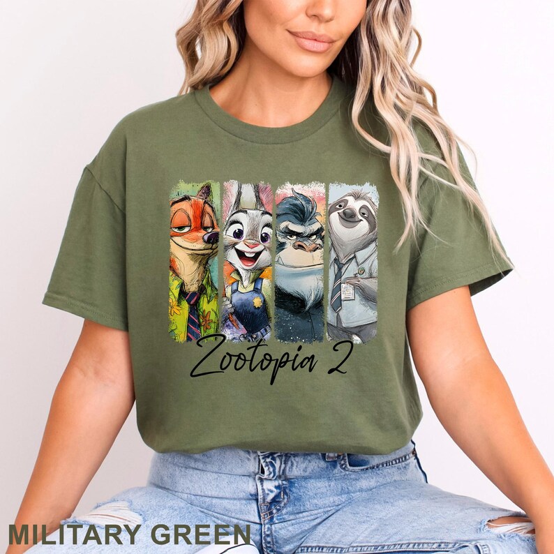 Peut inclure: T-shirt vert militaire avec un imprim&eacute; color&eacute; des personnages de Zootopie. L'illustration comprend Nick Wilde, Judy Hopps, Chef Bogo et Flash. Le texte "Zootopia 2" est &eacute;crit en dessous des personnages.
