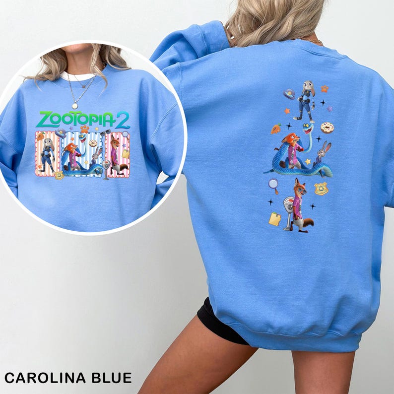 May include: Carolina blue sweatshirt featuring the text "ZOOTOPIA 2" with cartoon characters. The back of the sweatshirt displays additional Zootopia characters. A fun and colorful design for fans of the animated movie.
