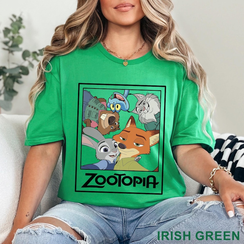 Peut inclure: T-shirt vert irlandais avec un motif des personnages du film d'animation Zootopie. Le motif est dans un cadre rectangulaire noir avec le mot "Zootopia" en blanc. Le t-shirt est &agrave; col rond et &agrave; manches courtes.