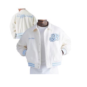 May include: Cream-colored varsity jacket with light blue accents. Features a large "B" patch and the word "Official" embroidered on the back. The jacket has a button-up front and striped cuffs and hem.