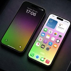 Könnte beinhalten: Zwei Smartphones mit Farbverlaufsanzeigen. Eines zeigt Uhrzeit und Datum an, das andere App-Symbole. Die Bildschirme haben einen Farbverlauf aus Grün, Gelb und Lila. Die Telefone liegen auf einer dunklen Oberfläche.