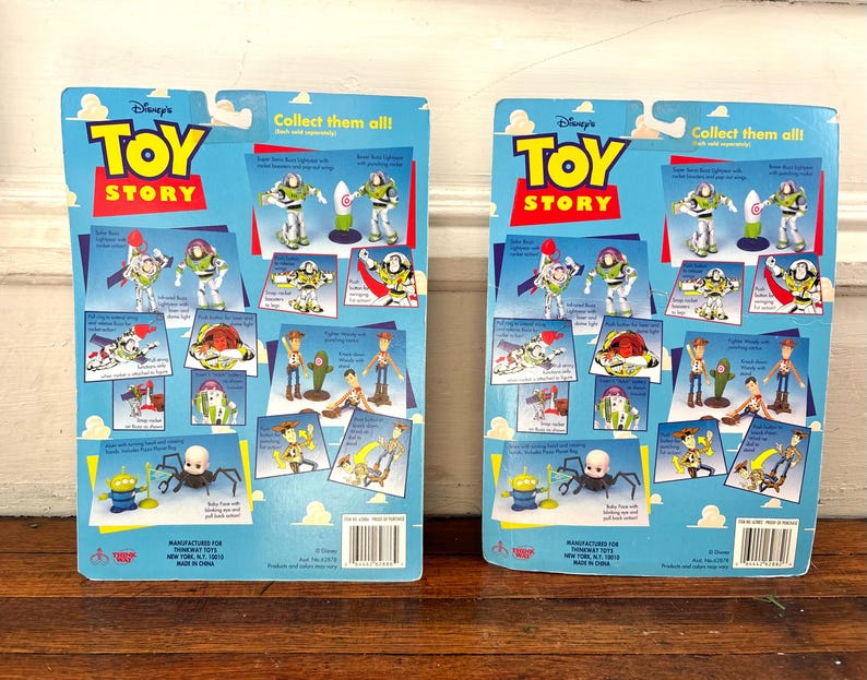 Może przedstawiać: Dwa tyły kart z figurkami Toy Story. Niebieskie karty zawierają zdjęcia Buzza Astrala, Chudego i innych postaci. Logo Toy Story jest w kolorze czerwonym i ż&oacute;łtym. Tekst "Collect them all!" znajduje się na g&oacute;rze.