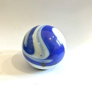 May include: A vintage marble with a swirl pattern of blue and white. The glass marble is round and has a glossy finish. The marble is a classic toy and collectible item.