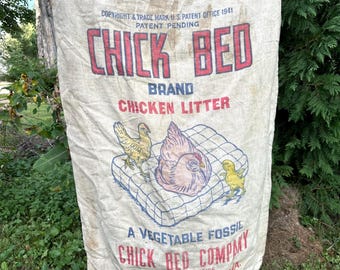May include: A vintage beige burlap sack featuring the red and blue text CHICK BED BRAND CHICKEN LITTER, A VEGETABLE FOSSIL, CHICK BED COMPANY, CEDAR RAPIDS, IOWA. The graphic depicts a hen and two chicks on a grid pattern with patent details.