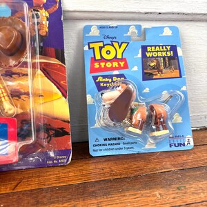 Peut inclure: Un porte-cl&eacute;s Slinky Dog emball&eacute; du film Disney Toy Story. L'emballage bleu et jaune pr&eacute;sente le logo Toy Story et les mots "REALLY WORKS!". L'emballage comprend &eacute;galement un avertissement de risque d'&eacute;touffement.